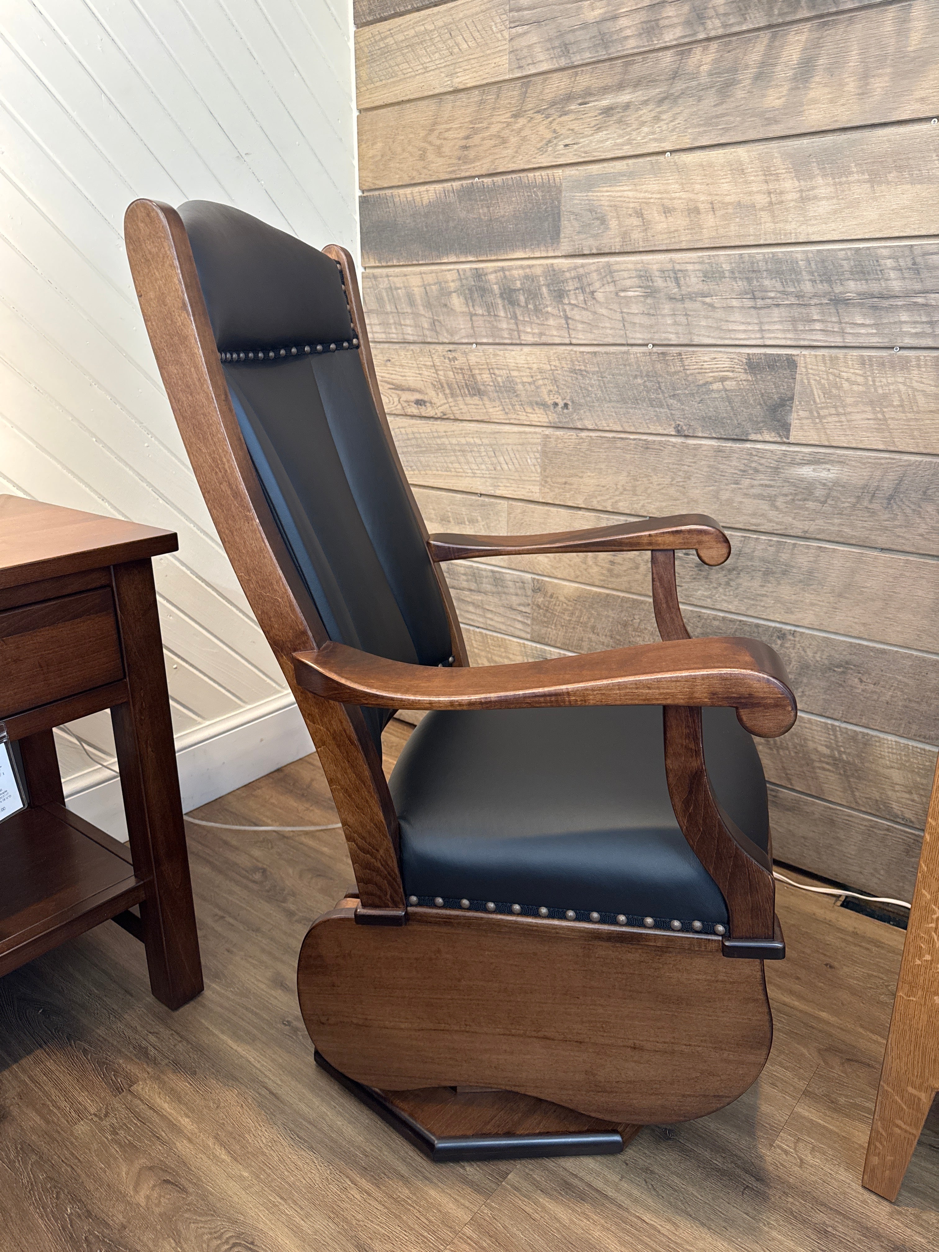 Side view of Amish made swivel glider rocker chair in solid maple hardwood with black leather upholstered cushions – handcrafted furniture